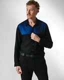 Modelo usando Camisa masculina de botão nas cores preta com recorte azul no peito.