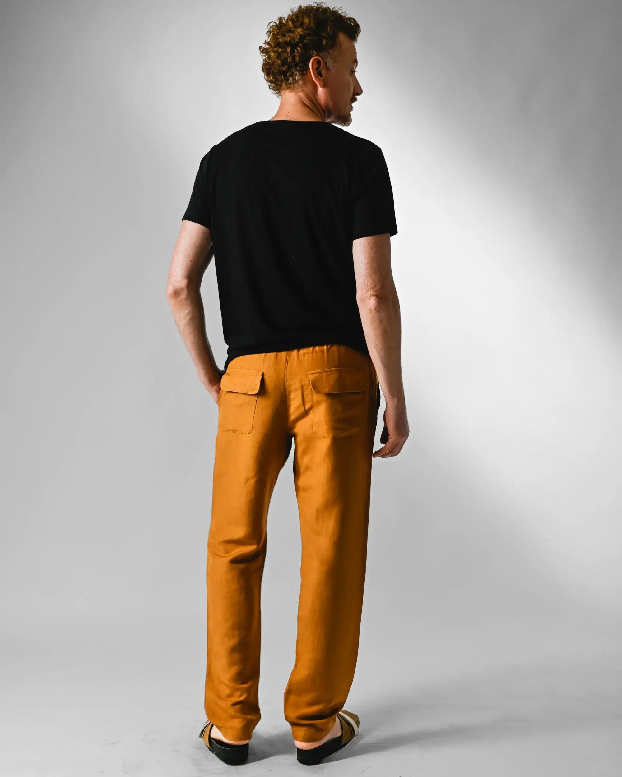 Look costas camiseta preta e calça terracota