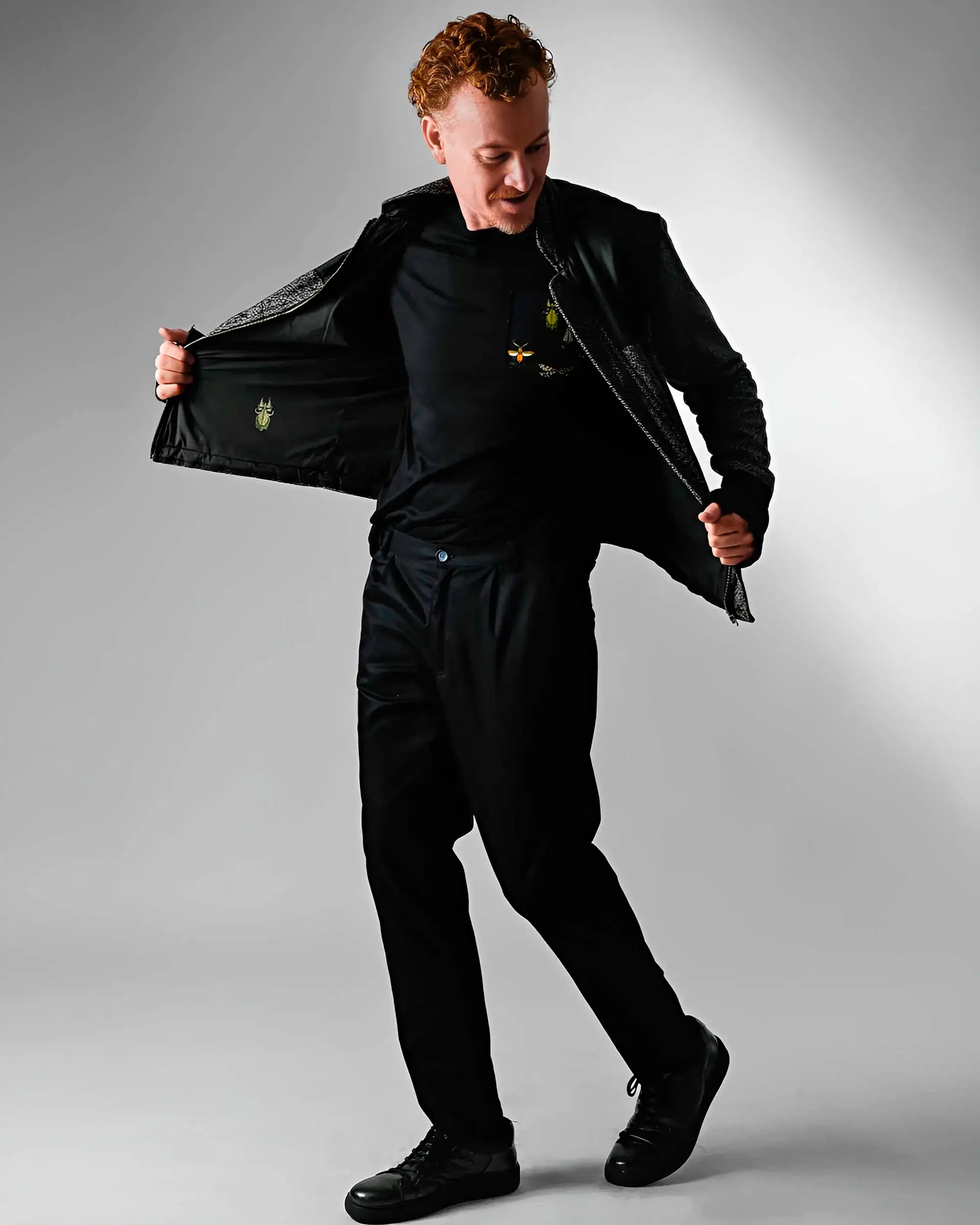 modelo fazendo pose usando a calça e a camiseta preta com a jaqueta